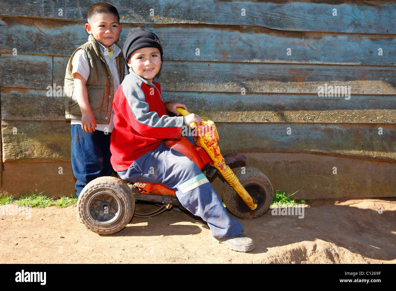 Zwei Jungs spielen mit einem Dreirad, Mapuche-Indianer, in der Nähe von Concepción, Süd-Chile, Chile, Südamerika Stockfoto