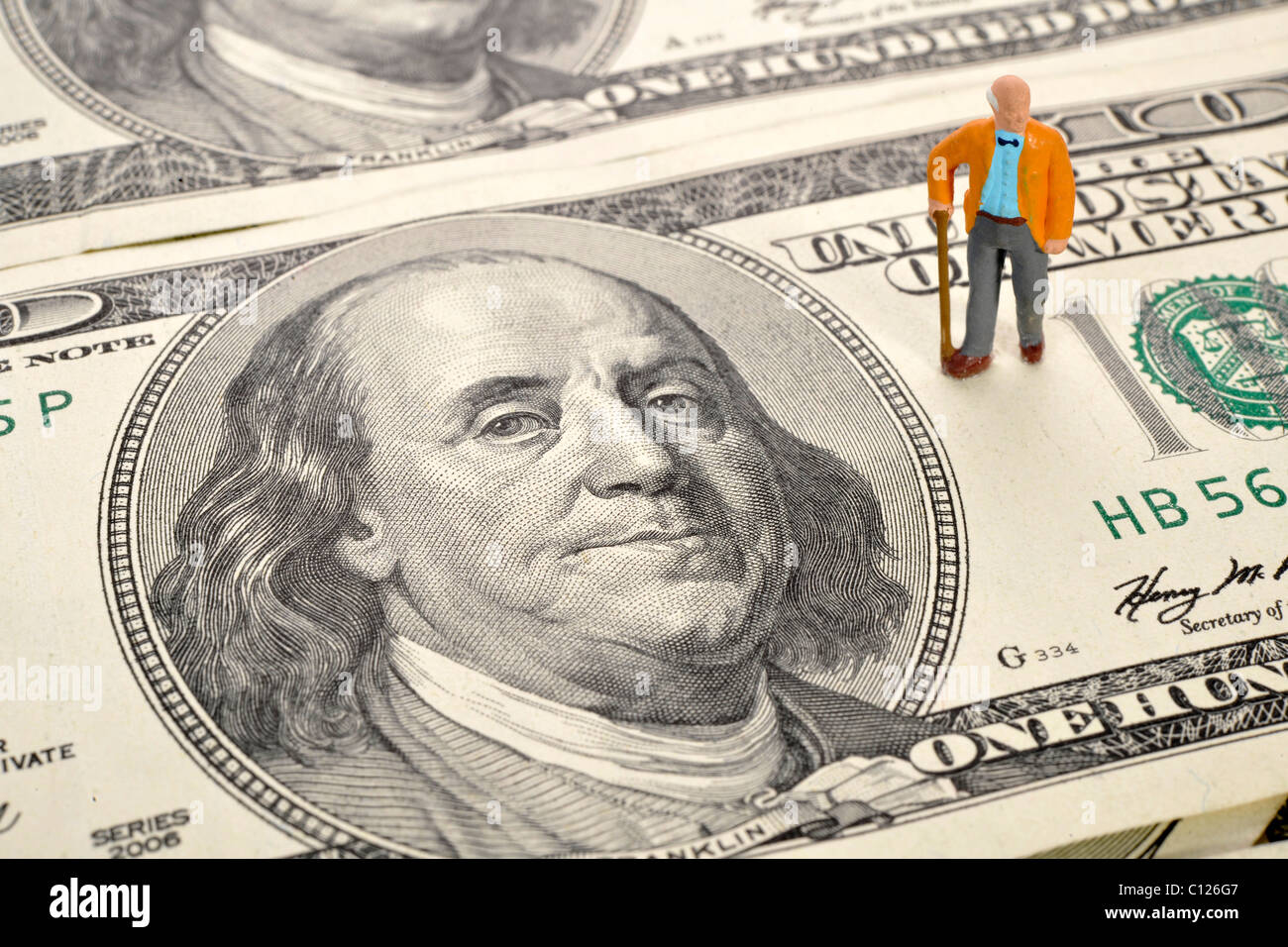 Rentner-Miniatur-Abbildung, 100-Dollar-Scheine, symbolisches Bild für Rente, Altersvorsorge Stockfoto