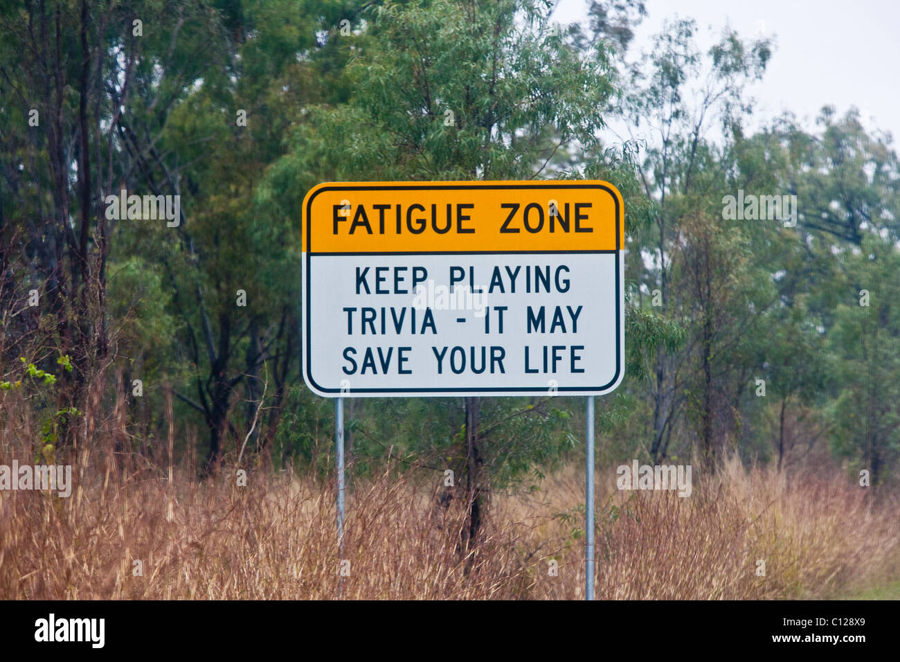 Humorvolle Australian Road Sign Warnung vor Gefahren von Müdigkeit auf langen Reisen. Queensland, Australien Stockfoto