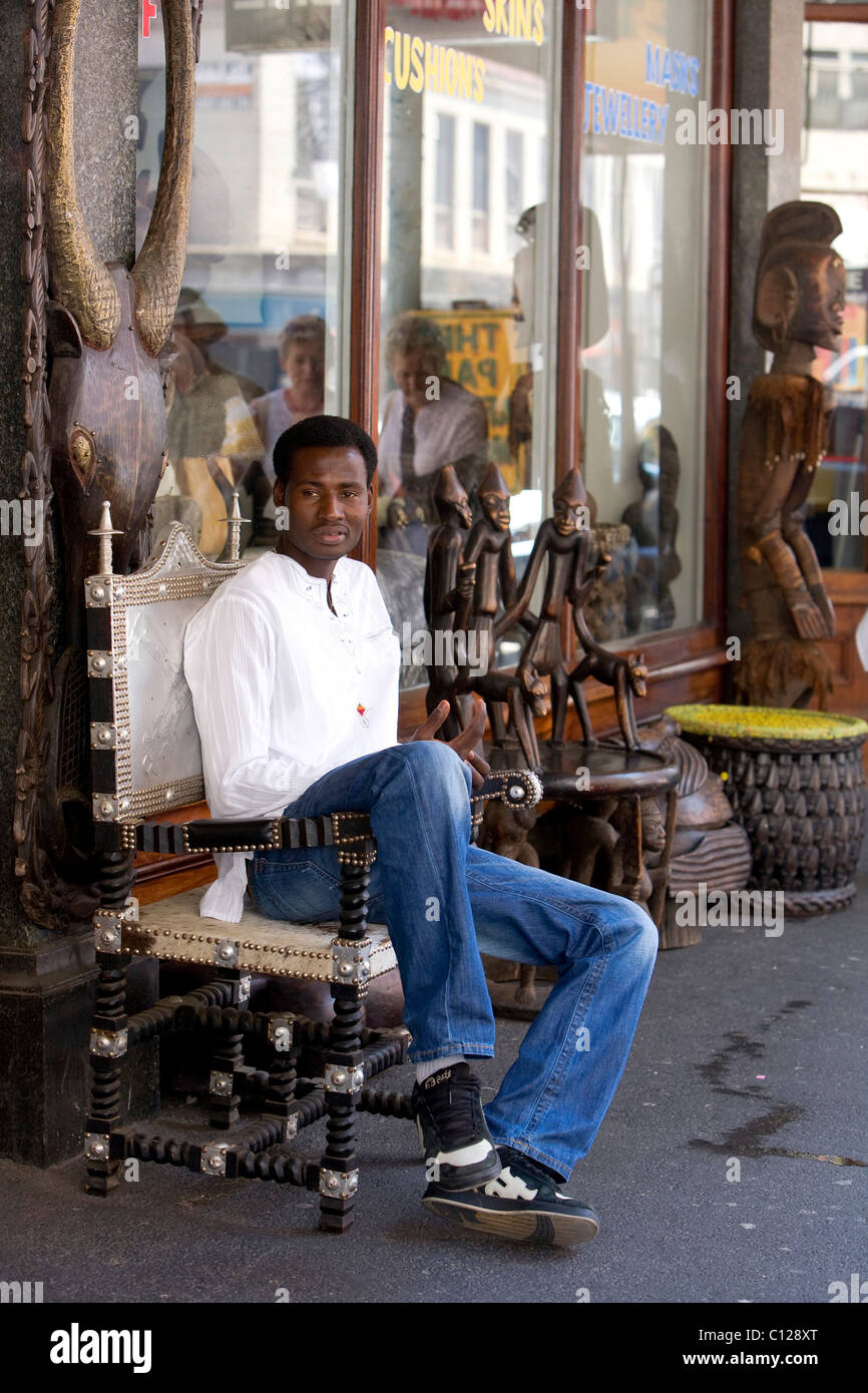 Kunst und Kunsthandwerk-Shop, Afrikaner sitzen direkt vor dem Geschäft auf der Long Street, Kapstadt, Western Cape, Südafrika, Afrika Stockfoto