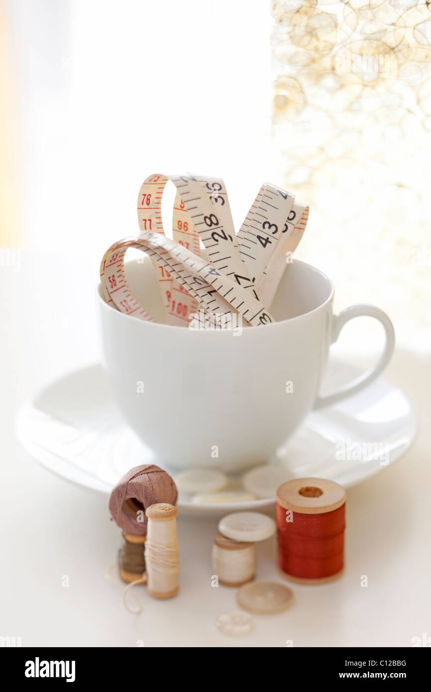 Tee Tasse halten Messen Band und Faden und Nähen Artikel Stockfoto