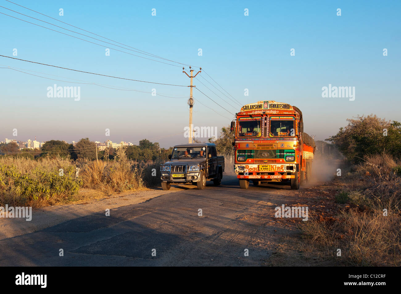 Indien Transport LKW entlang einer Straße überholt von einem 4 x 4-Fahrzeug in der indischen Landschaft reisen. Andhra Pradesh, Indien Stockfoto