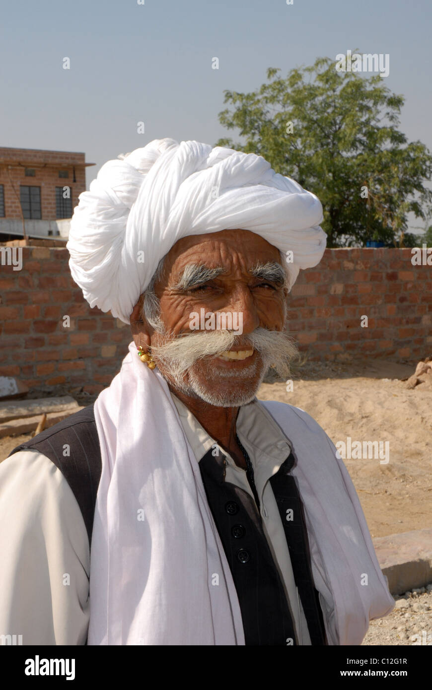 Portrait der Rajasthani lächelt glücklich Mann im Weißen turban am Arbeitsplatz Stockfoto