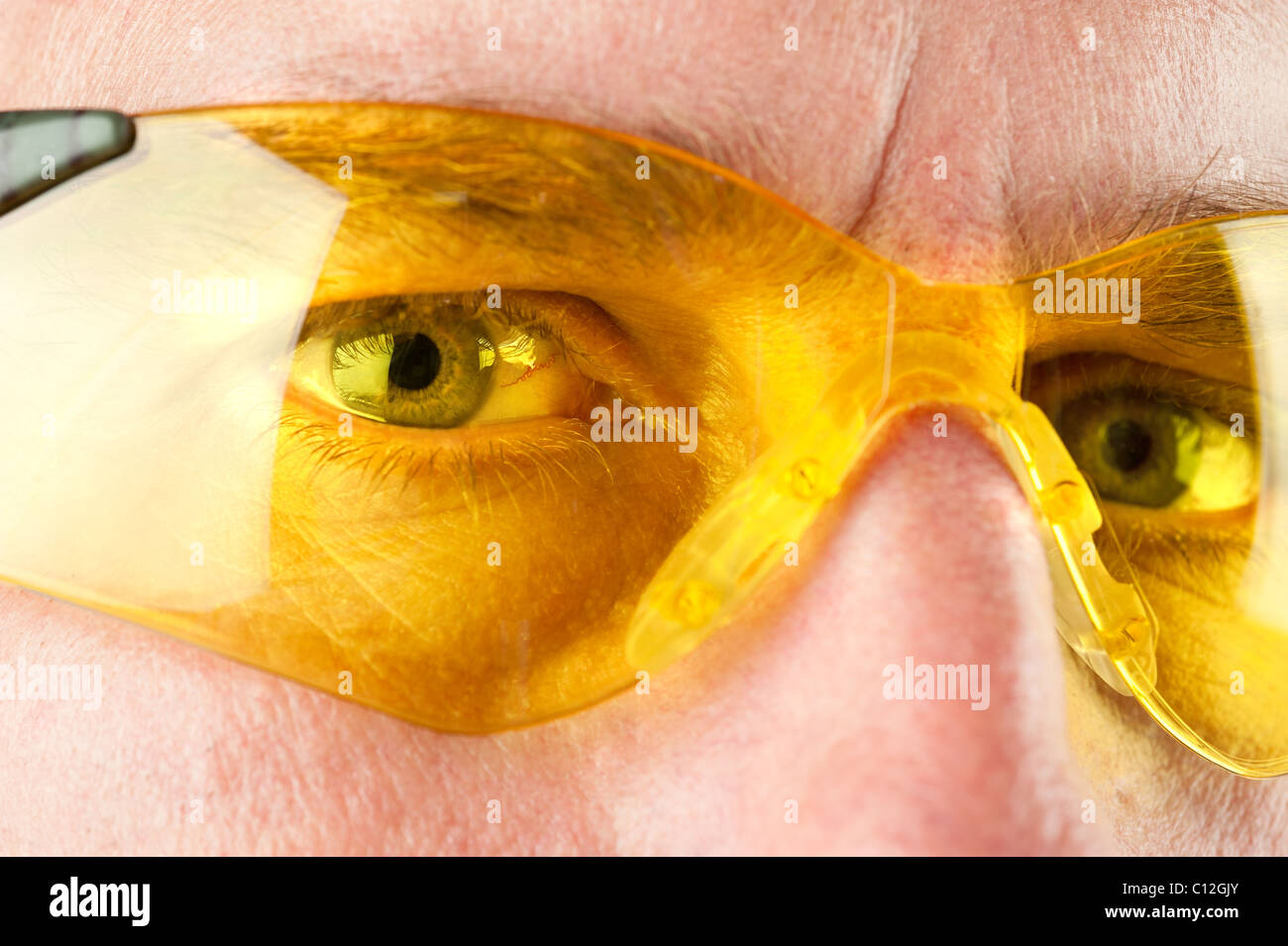Nahaufnahme eines Mannes mit gelbem Auge Schutzbrille Stockfoto