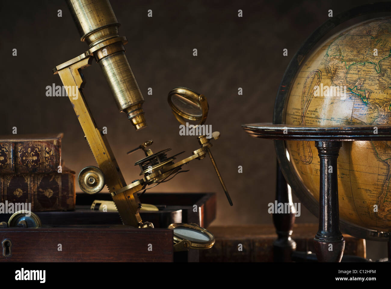 Altes Mikroskop und Globus Stockfoto