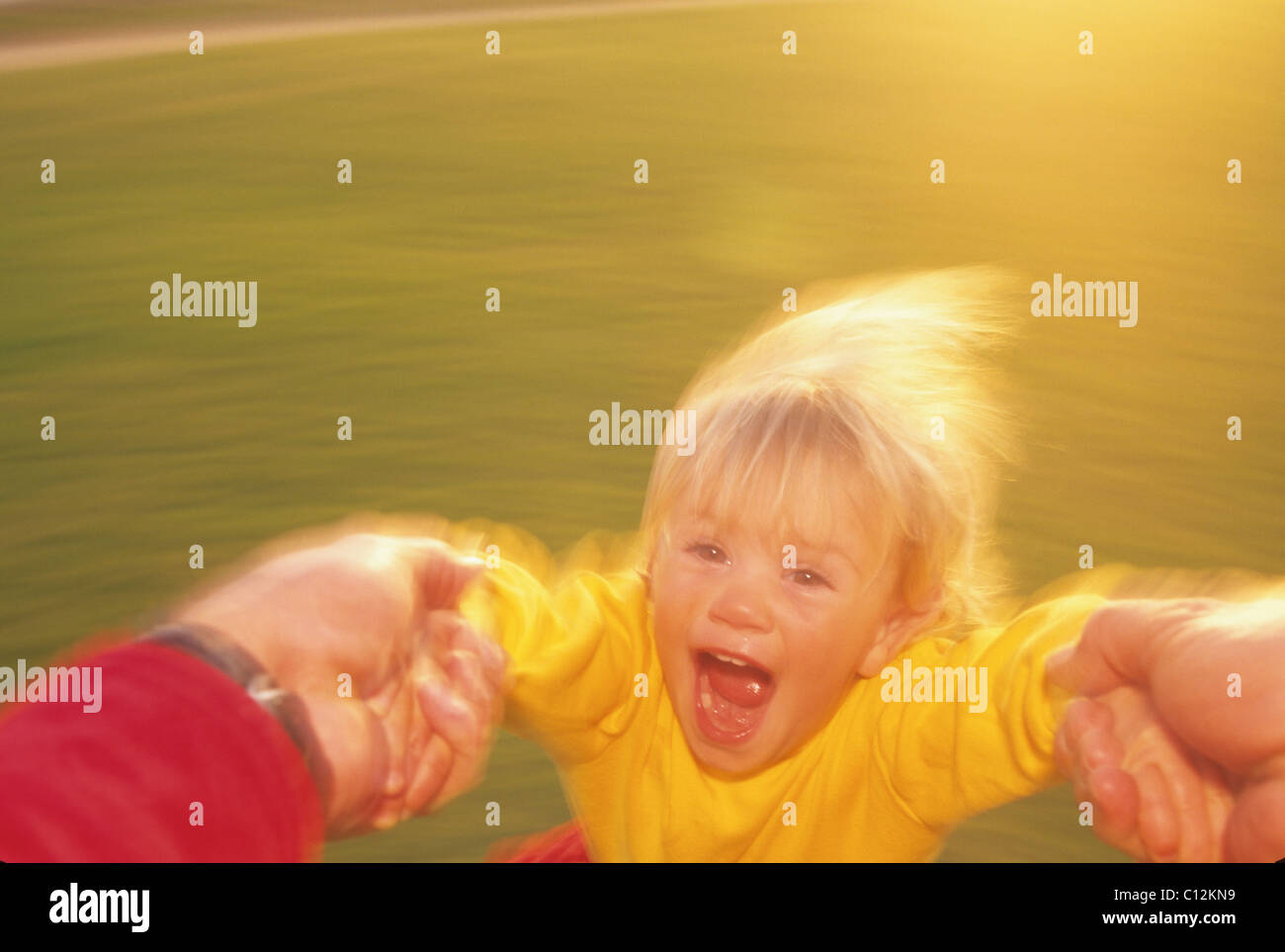 Erwachsene Die Ein Kind Im Kreis Drehen Stockfotografie Alamy
