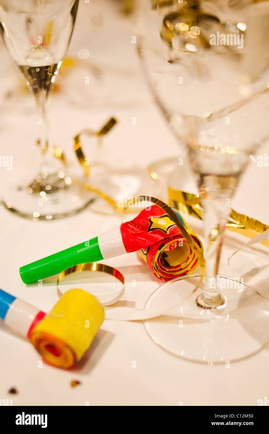 Party-Horn-Gebläse und Sektgläser auf Tisch, Nahaufnahme Stockfoto