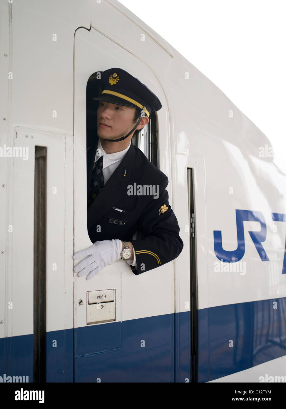 Shinkansen Bullet train Dirigent Kontrollen die Plattform wie der Zug aus Osaka Station gebunden für Tokio zieht. Stockfoto