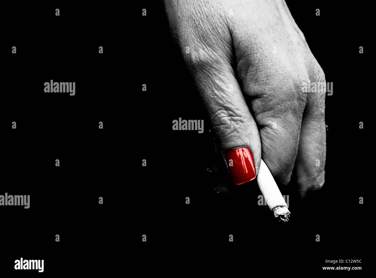 Frau mit roten Nägeln hält eine Zigarette Stockfoto