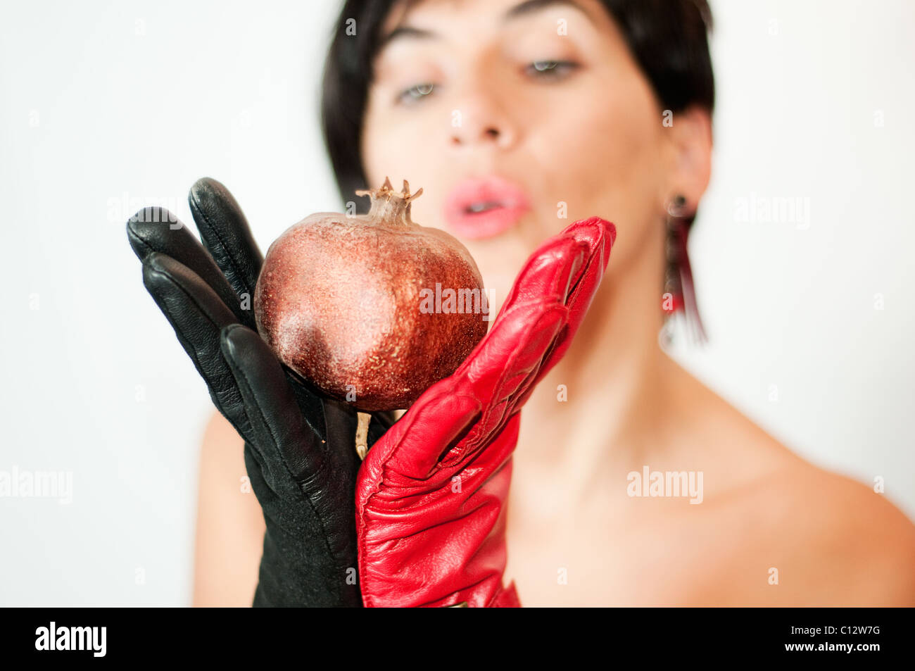Frau mit Granatapfel in roten und schwarzen Handschuhen Stockfoto