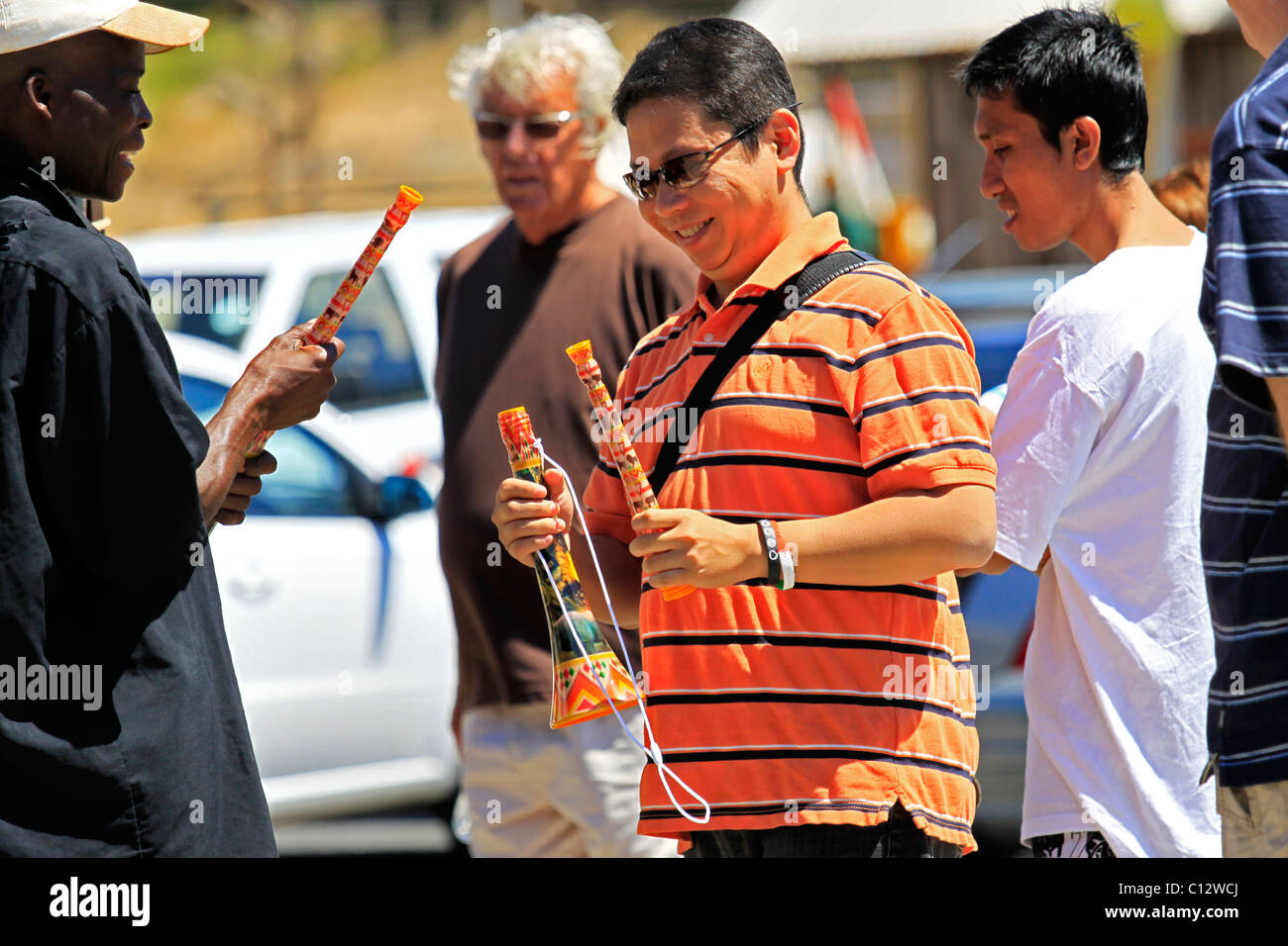 Touristische kauf Vuvuzela von Anbieter bei Hout Bay Hafen in der Nähe von Kapstadt. Stockfoto