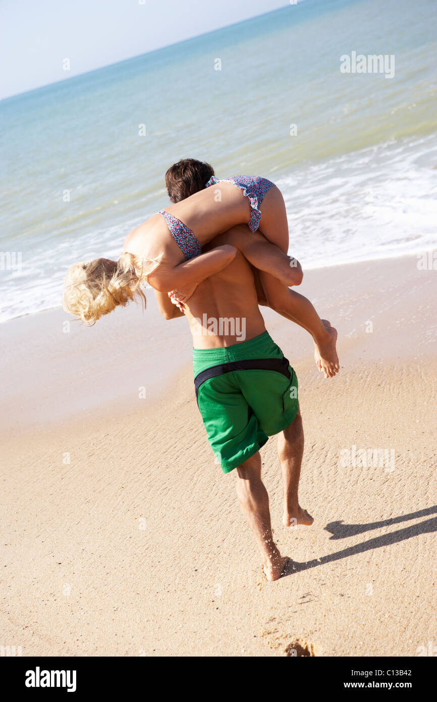 Junges Paar spielen am Strand Stockfoto