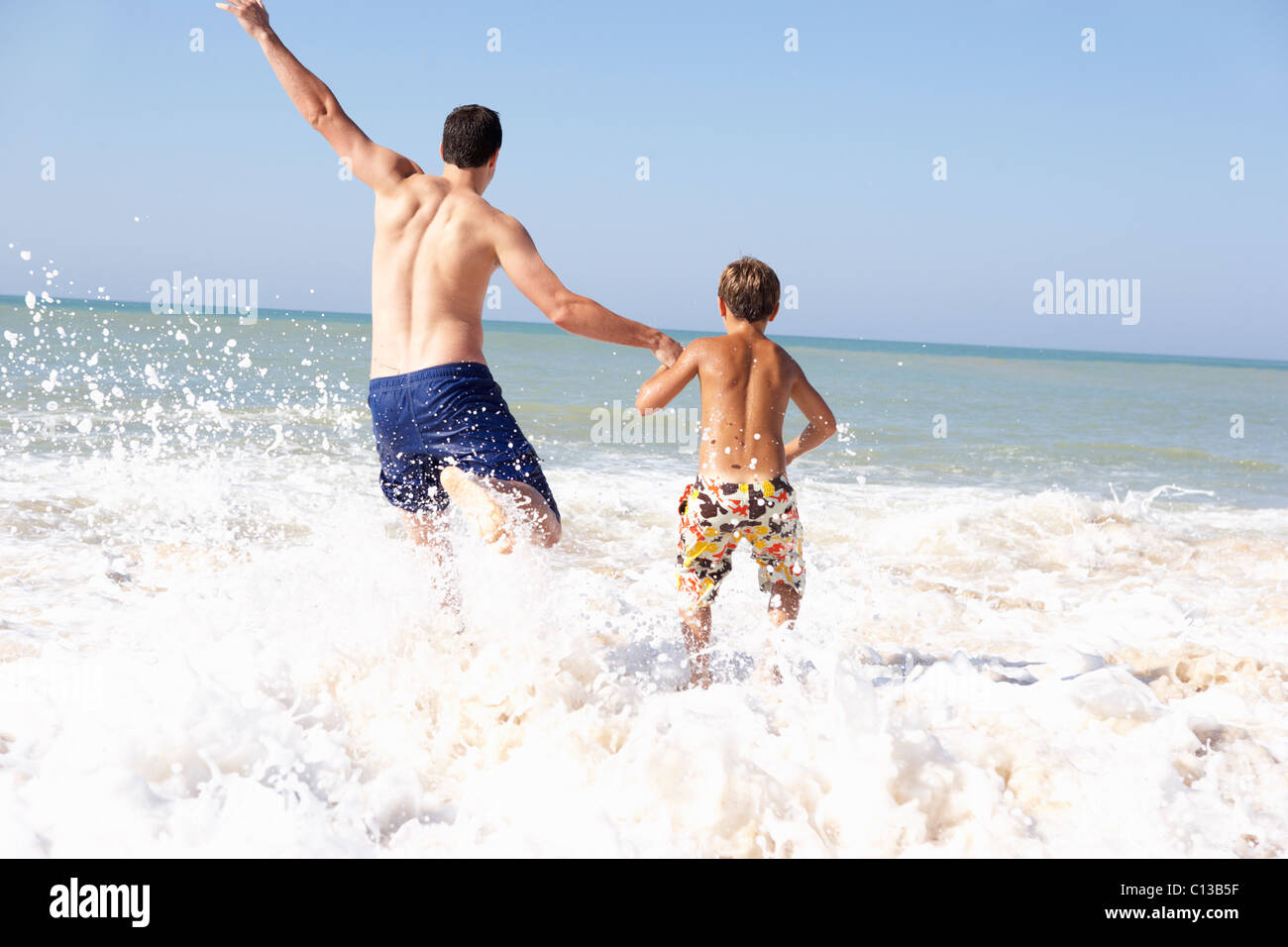 Vater mit kleinen Jungen am Strand spielen Stockfoto