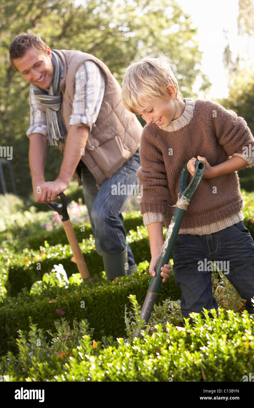 Junger Mann mit Kind im Garten arbeiten Stockfoto
