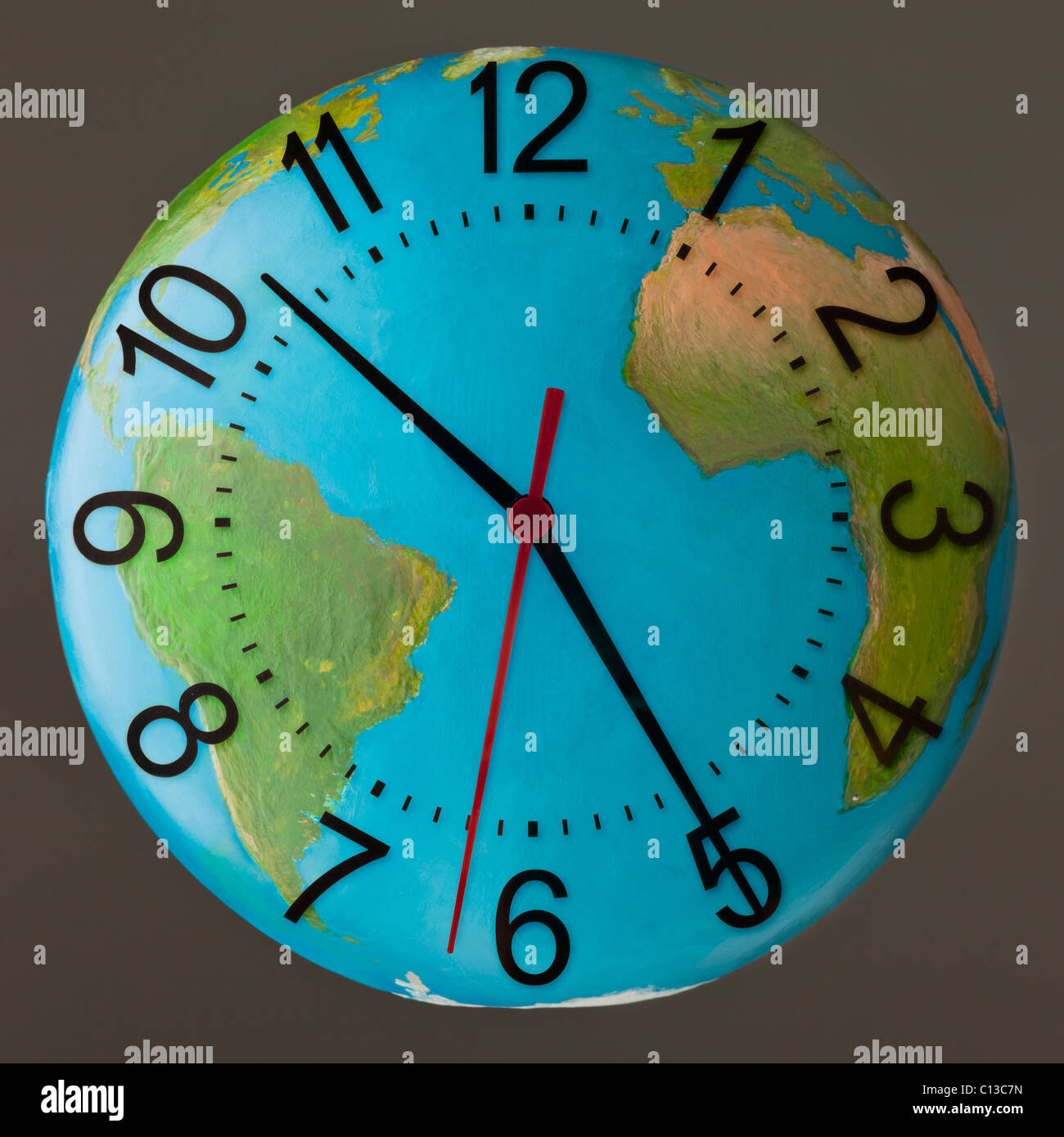 Studioaufnahme der Uhr eingebettet im globe Stockfoto