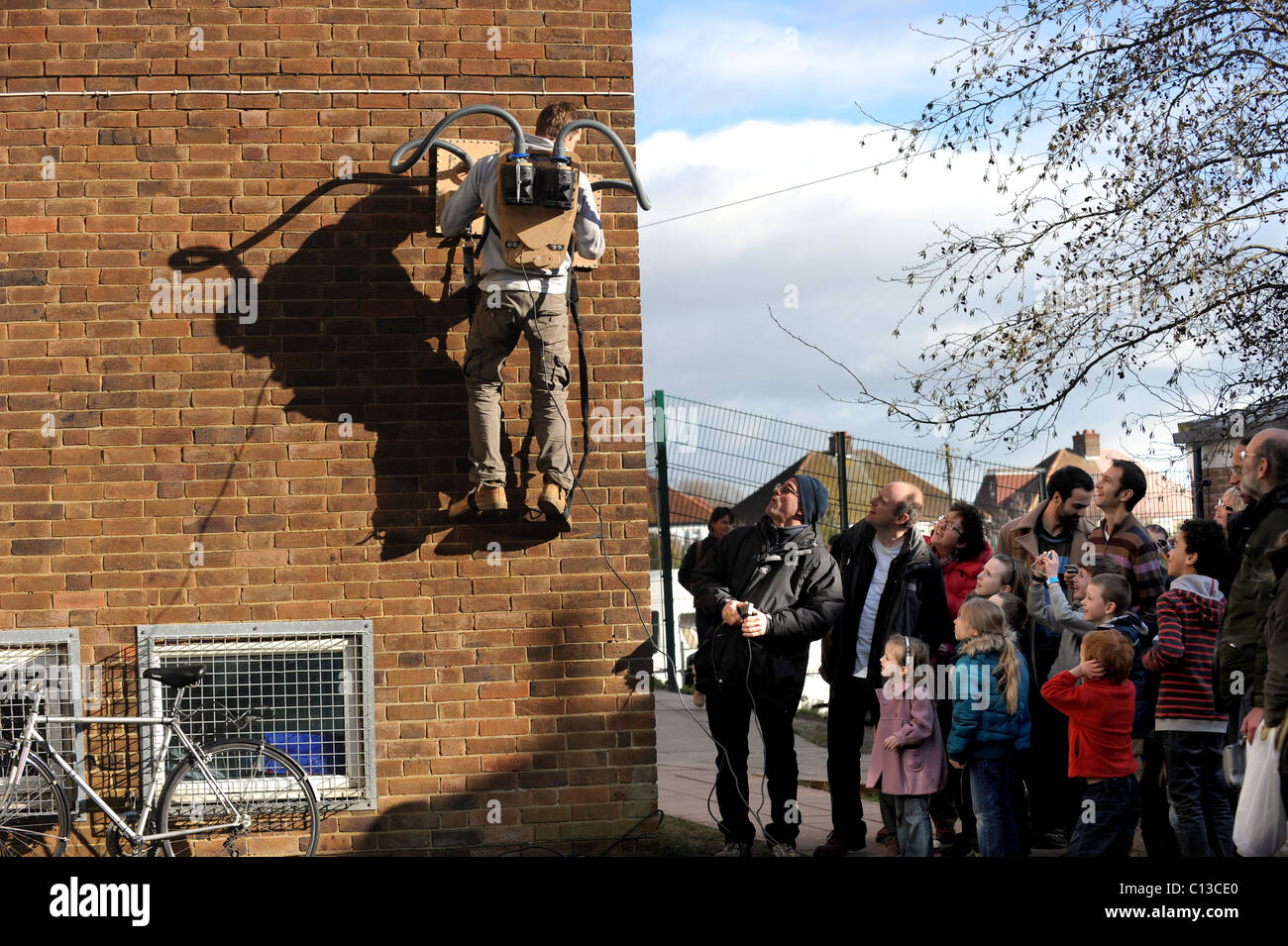 Knall geht die Theorie Moderatorin Jem Stansfield eine Wand mit zwei Staubsauger während der Brighton Wissenschaftsfestival skaliert Stockfoto