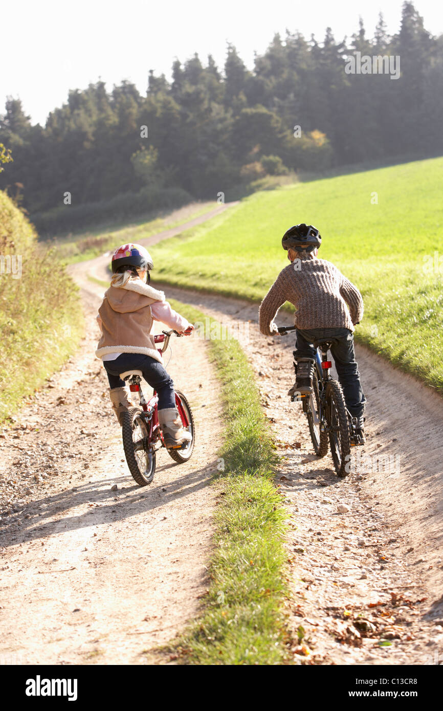 Zwei junge Kinder Reiten Fahrräder im park Stockfoto