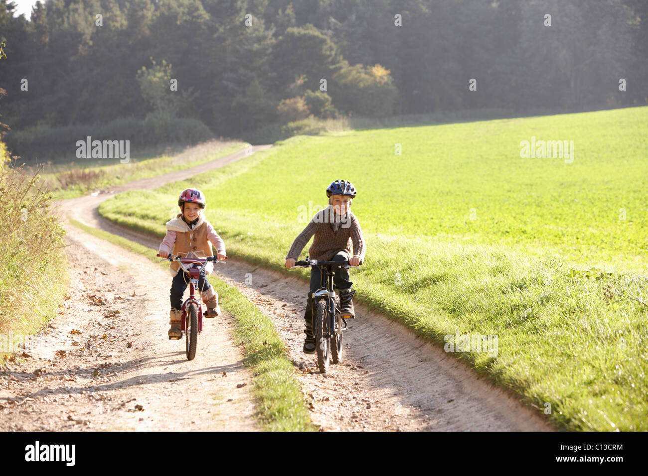 Zwei junge Kinder Reiten Fahrräder im park Stockfoto