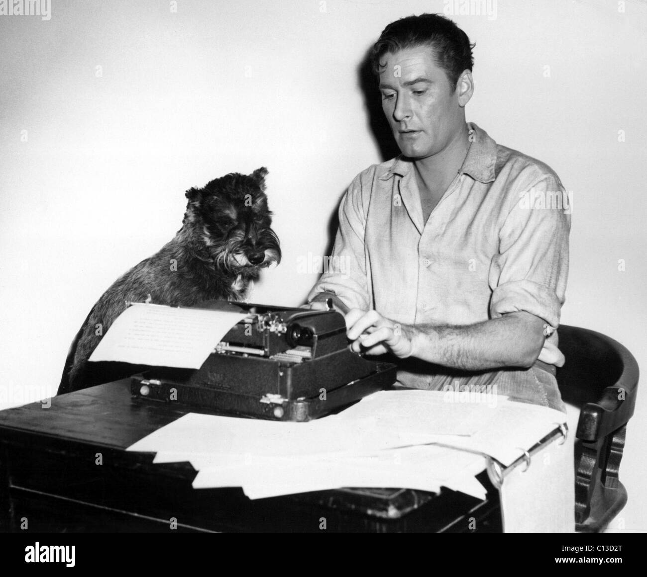 ERROL FLYNN bei der Arbeit an seinem Roman The Show Down, unter dem wachsamen Auge von MOODY sein Haustier Terrier, 1945 Stockfoto
