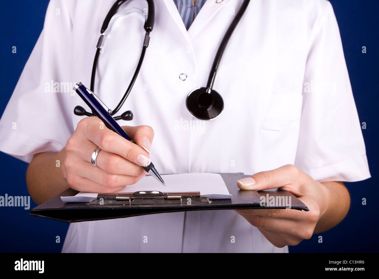 Arzt, Arzt oder Krankenschwester, über einen Ordner mit einem Füllfederhalter auf Papier zu schreiben. Stockfoto