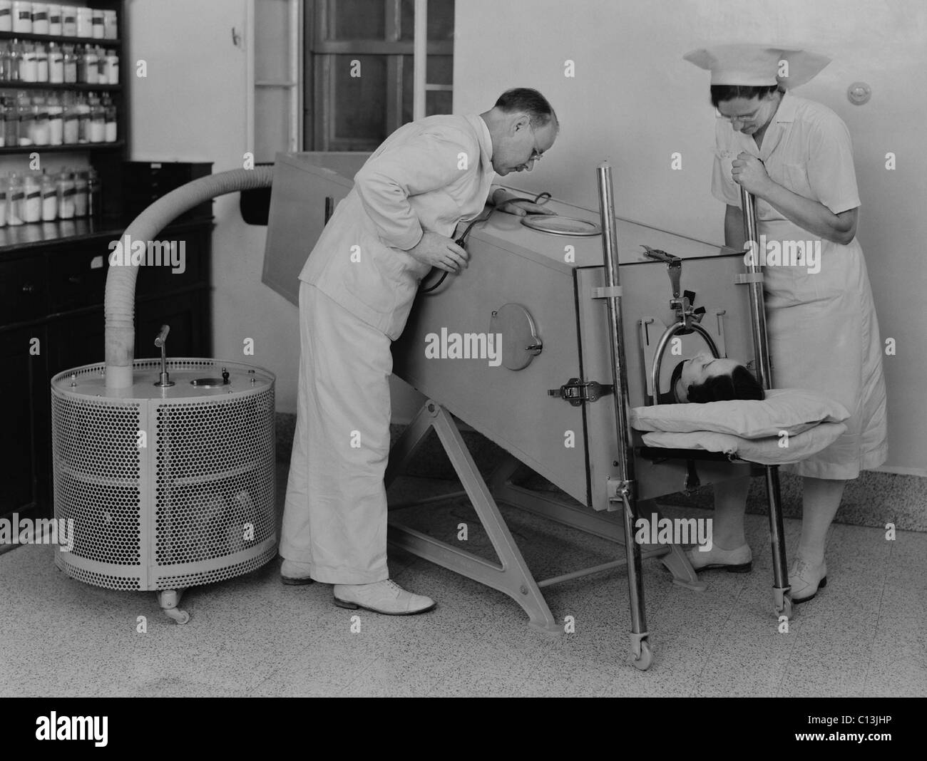 Polio-Patienten in einer eisernen Lunge am Schotten Missionskrankenhaus in Tiberias, Palästina im März 1940. Bei Kinderlähmung Muskeln, die geschwächten in der Atmung, einer eiserne Lungenkrebs, an eine große Luftpumpe angeschlossen unterstützt die Atmung. Stockfoto