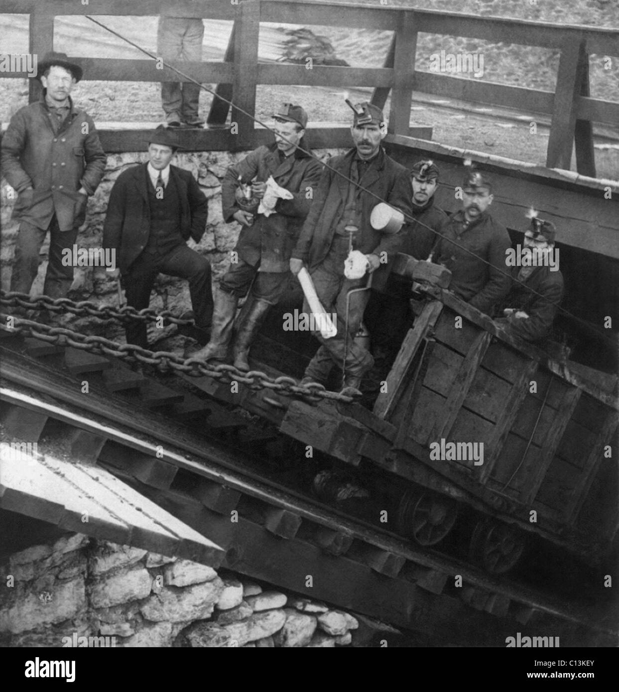 Fünf Bergleute gehen in den Hang, Abstieg in Coal mine, Hazelton, Pennsylvania. Beachten Sie den Mann in einem Anzug, stehend auf der Treppe, wahrscheinlich ein Manager. Einwanderer aus Osteuropa rekrutiert für den Bergbau, und viele ihrer Führungskräfte waren die ersten und zweiten Generation irischer Amerikaner. c1905. Stockfoto