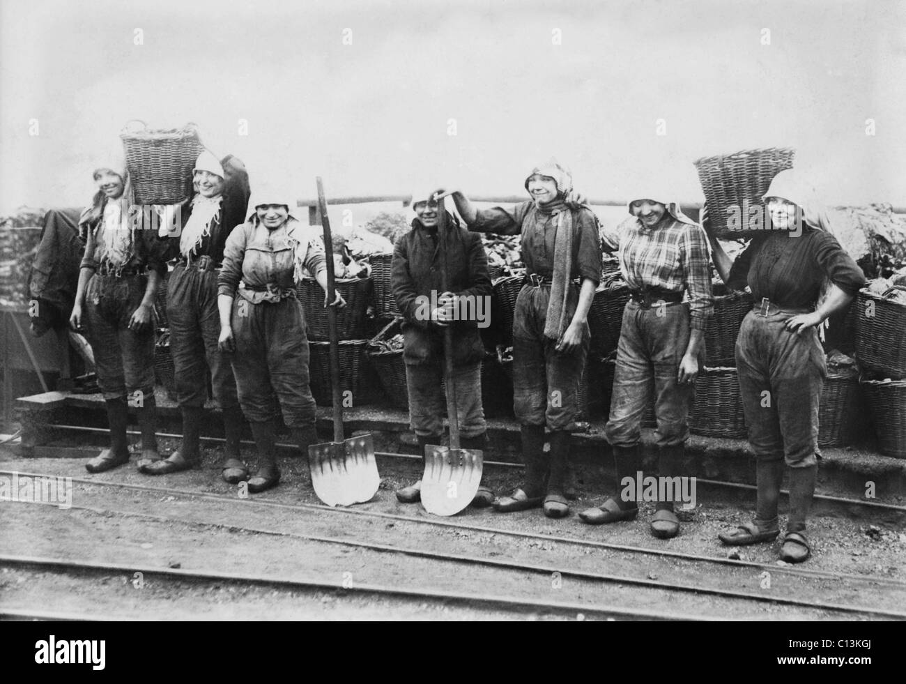 Belgische Frauen Kohle Bergleute in Hosen gekleidet. Sie tragen Arbeitnehmer Clogs und Kopftücher und enge Gürtel, die ihre Taille betonen. Zwischen 1900 und 1920. Stockfoto
