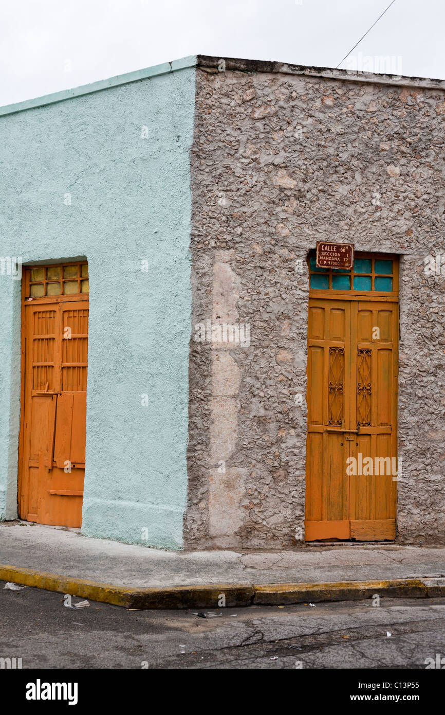 Straßenecke in Merida mit orange Türen: Calle 66a. Zwei lackierte etwa alte Türen an einer Straßenecke mit ein bisschen Müll Stockfoto