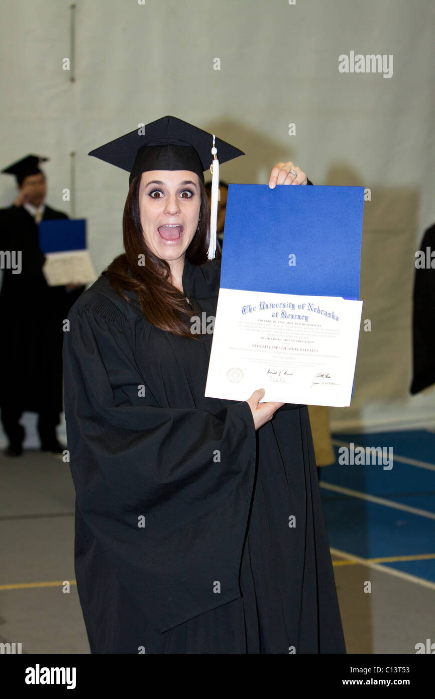 Eine Frau hält ihr Diplom nur nach dem Abschluss. Stockfoto