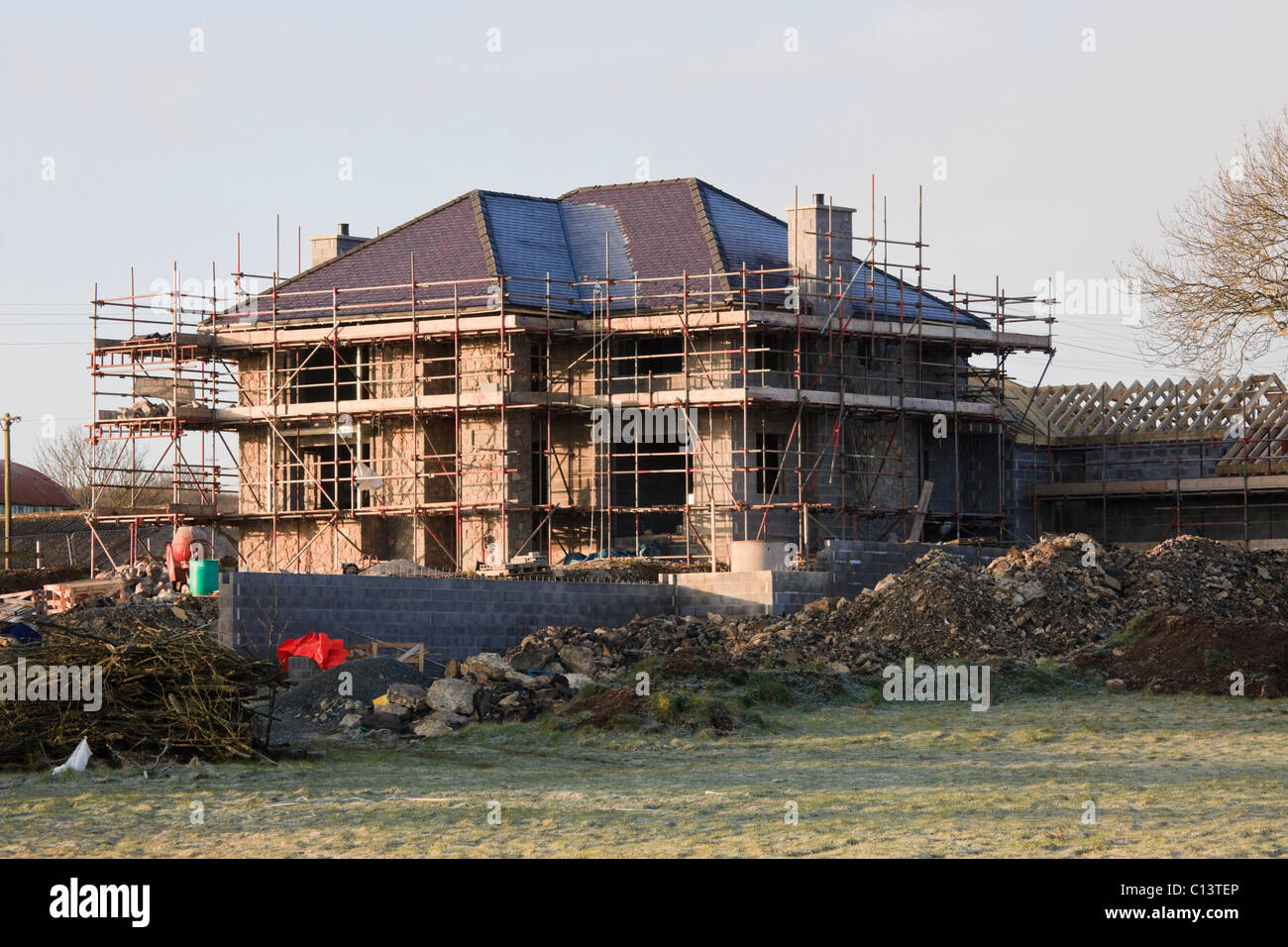 Gerüst auf ein großes neues Haus auf der grünen Wiese errichtet. Wales, UK, Großbritannien, Europa. Stockfoto