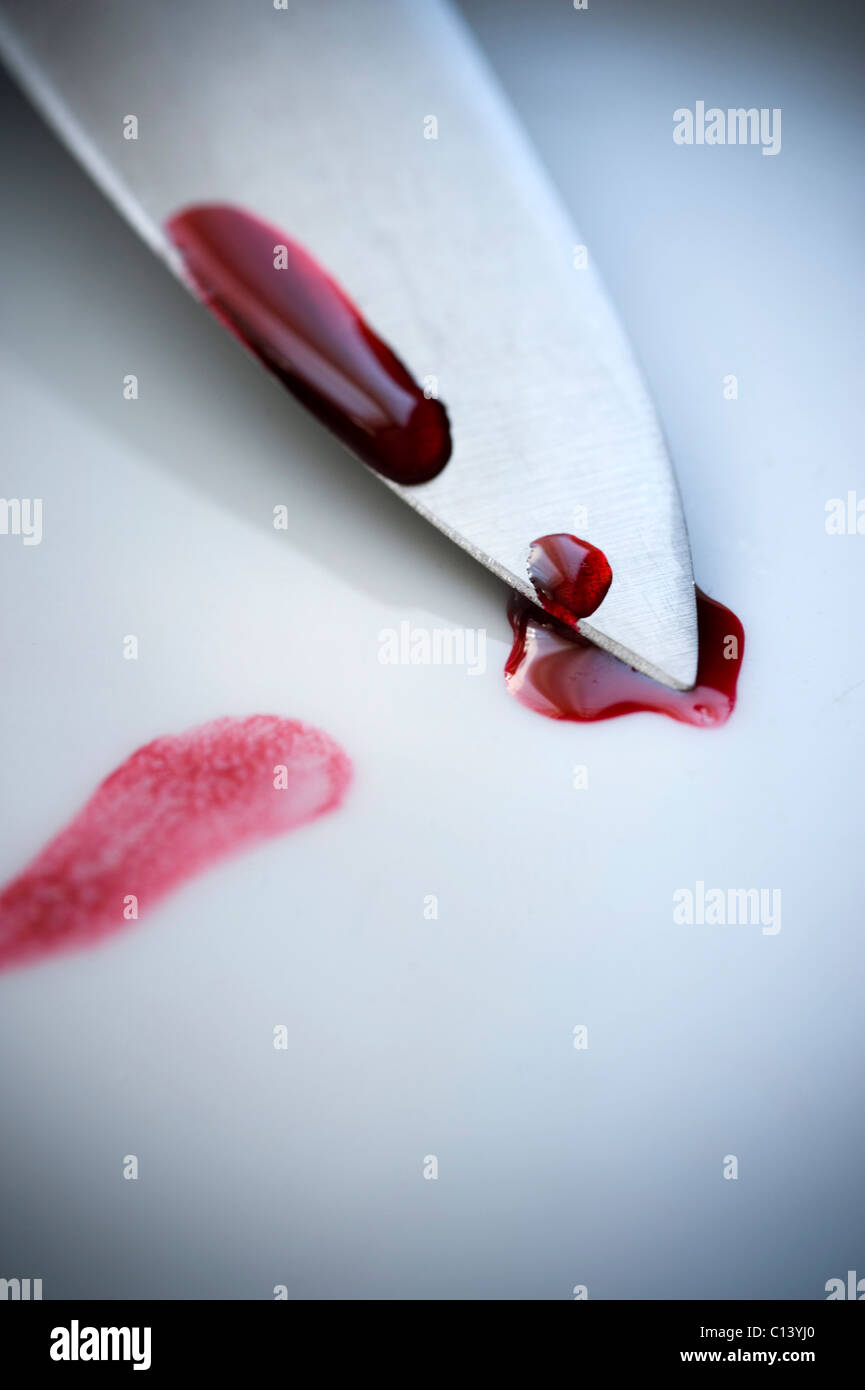 Klinge eines Messers auf einer weißen Fläche mit Blutstropfen von Stockfoto
