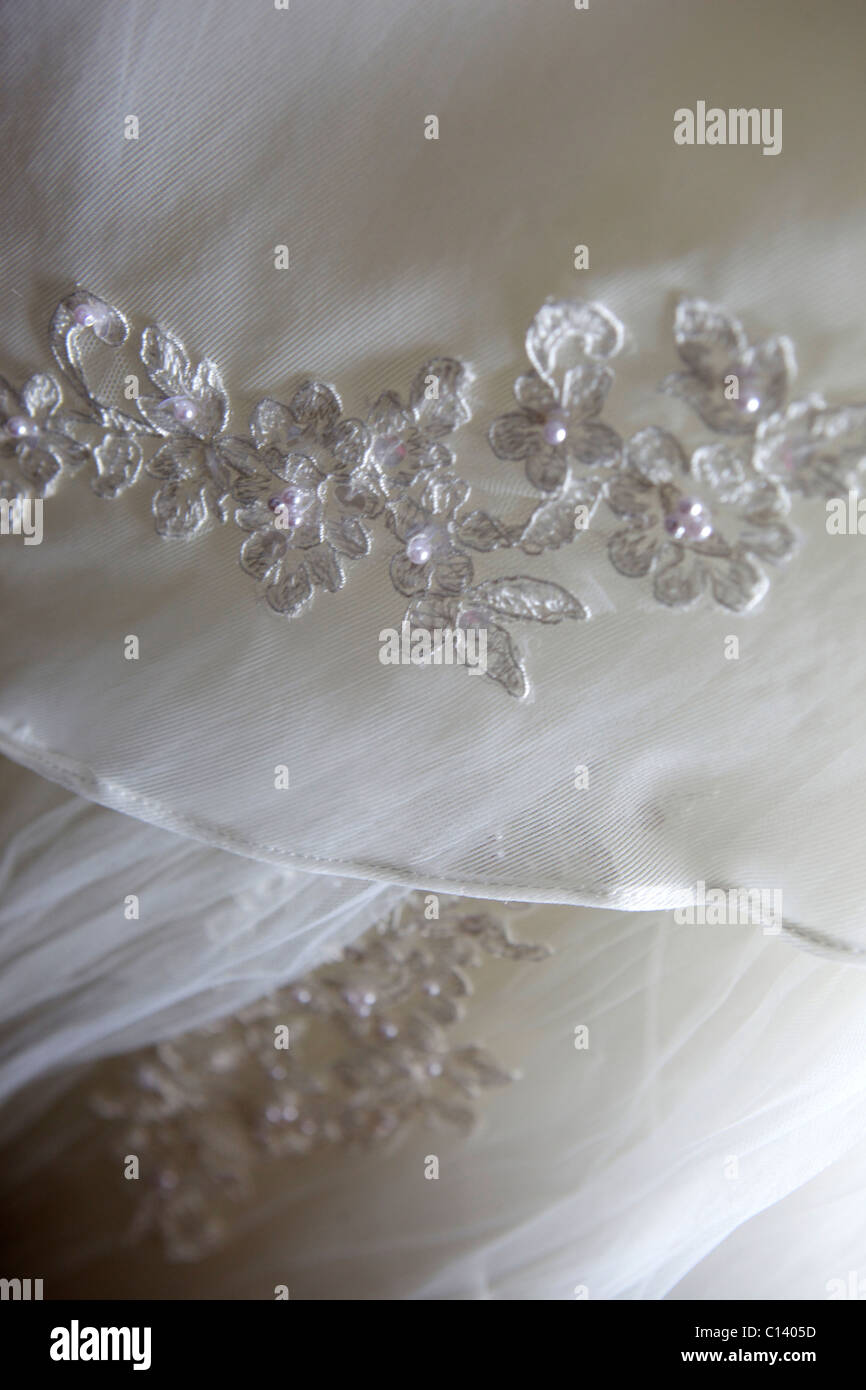 Hochzeitskleid in Nahaufnahme zeigt Detail Blumen auf dem Kleid. Stockfoto
