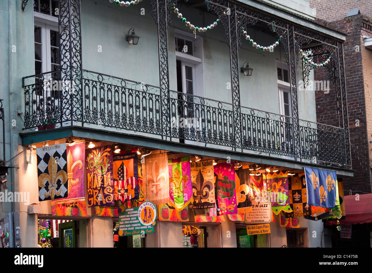 Souvenir-Shop mit hellen Banner unten schmiedeeisernen Balkon auf der Bourbon Street in New Orleans Stockfoto