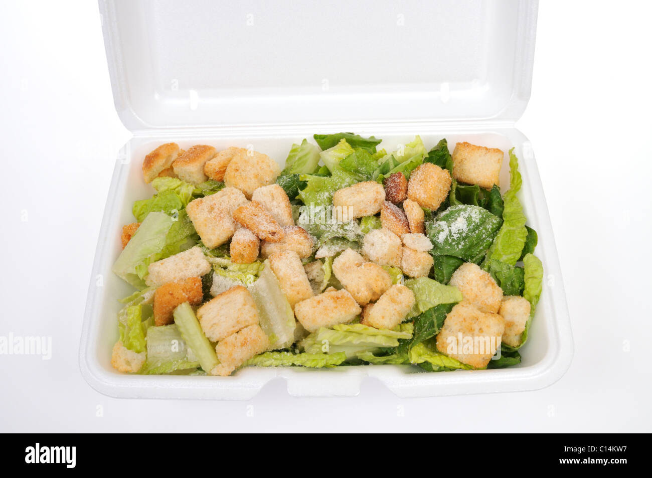 Verzehrbereit Caesar Salat mit Kopfsalat, Käse und Croutons in Styropor wegnehmen Box weißen Hintergrund, Ausschnitt. Stockfoto