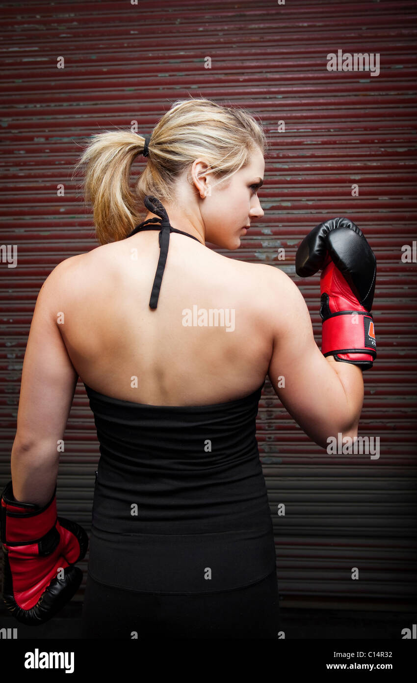Ein junges Mädchen zeigt ihre Muskeln während des Trainings für mixed Martial Arts außerhalb einer Lagerhalle in Birmingham, Alabama. Stockfoto