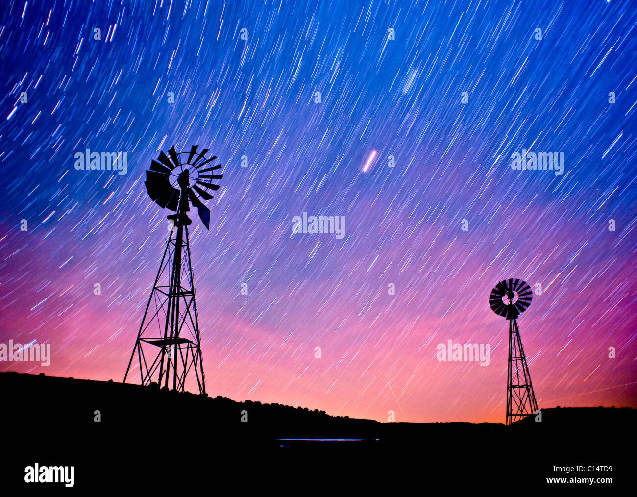 Zwei Windmühlen mit Sternspuren am Himmel.  La Junta, Colorado. Stockfoto