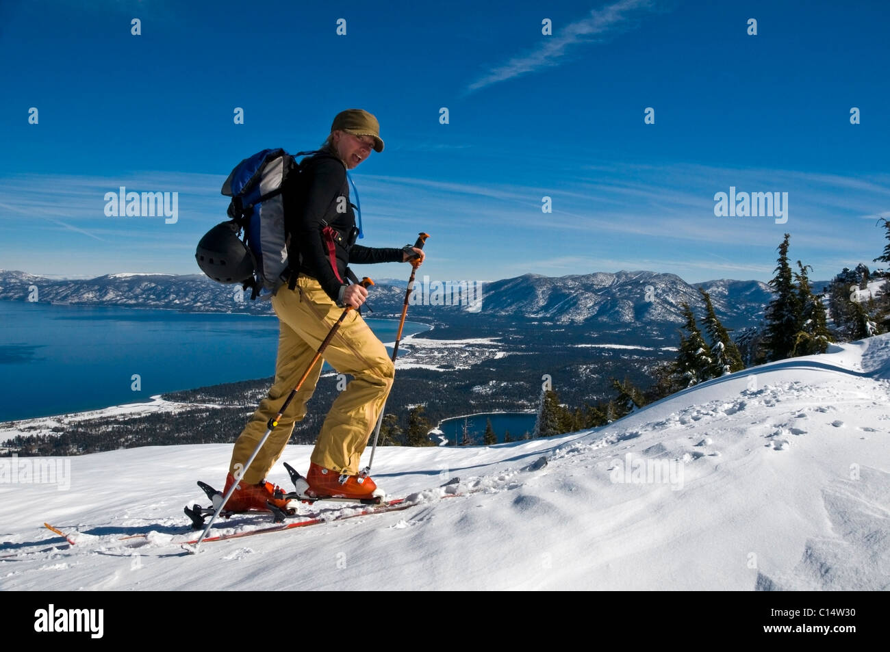 Eine Skifahrerin Skins oben Mount Tallac mit Lake Tahoe im Hintergrund, CA. Stockfoto