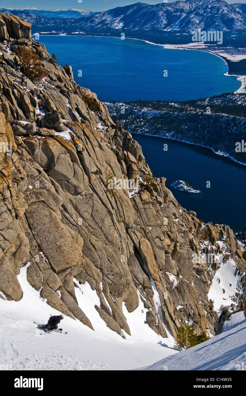 Ein Skifahrer steigt im Winter CA Emerald Rutsche hoch über Emerald Bay und Lake Tahoe. Stockfoto