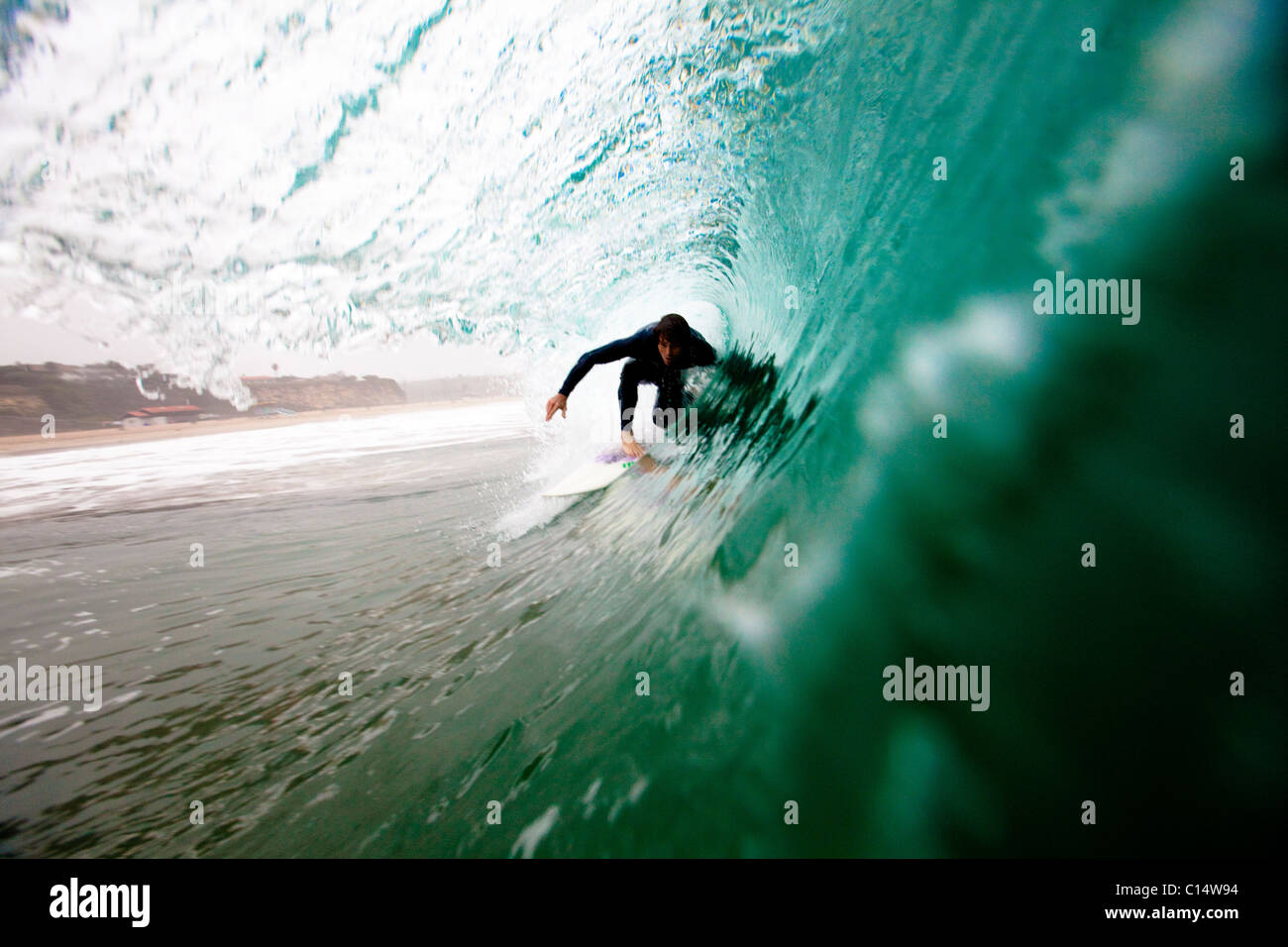 Eine männliche Surfer zieht in ein Fass beim Surfen bei Zuma Beach in Malibu, Kalifornien. Stockfoto