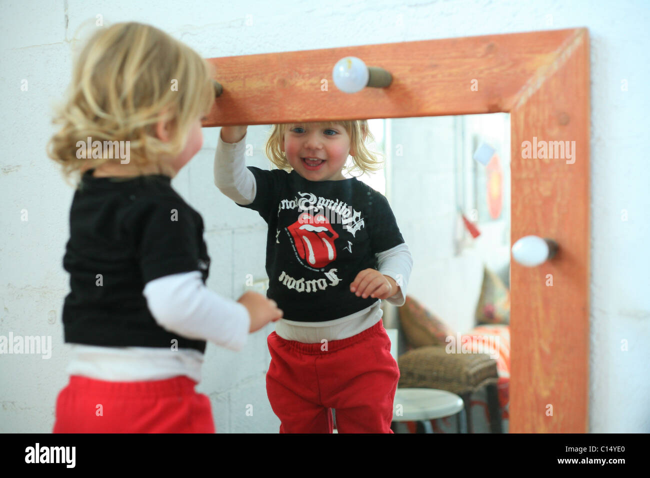 Junge Kleinkind zwei schaut sich im Spiegel Stockfoto