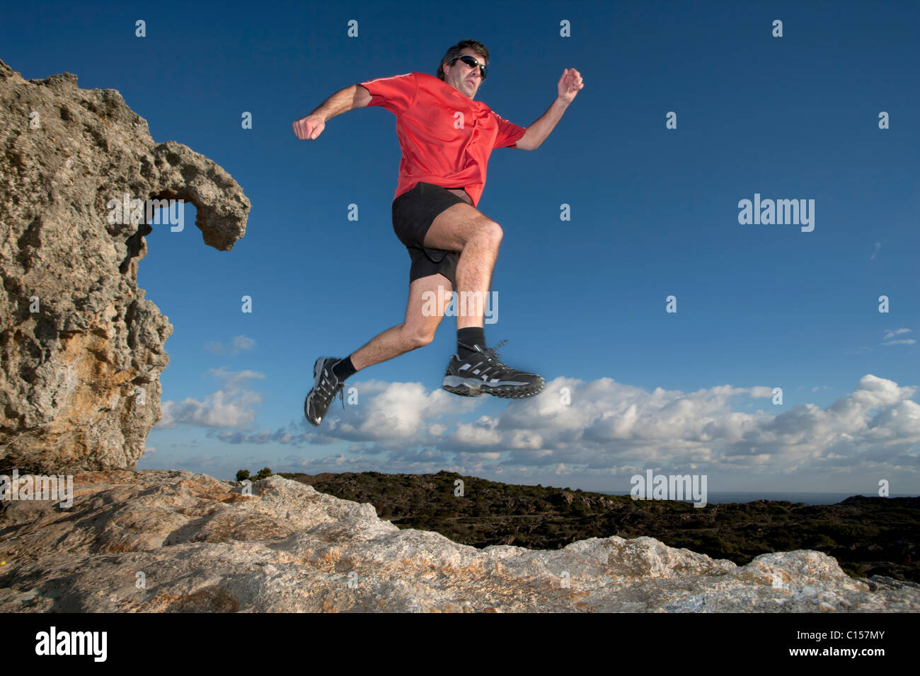 Mann läuft über felsiges Gelände im Naturpark des Cap de Creus, Katalonien, Spanien Stockfoto