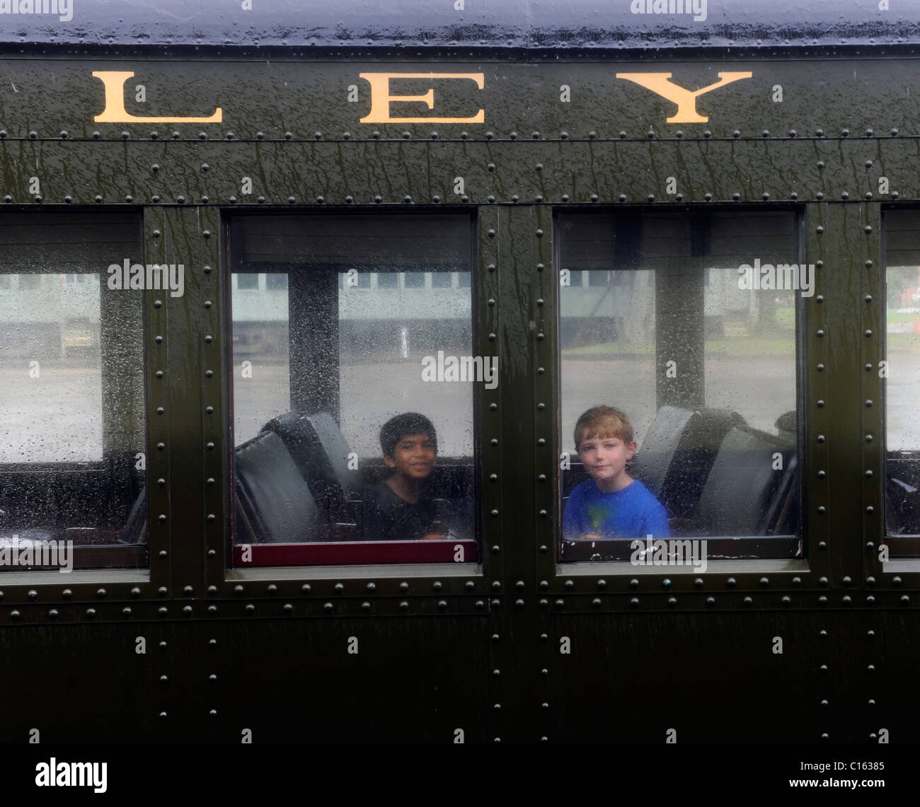 7 Jahre alten Jungen fahren den historischen Dampfzug der Essex an einem regnerischen Tag Stockfoto