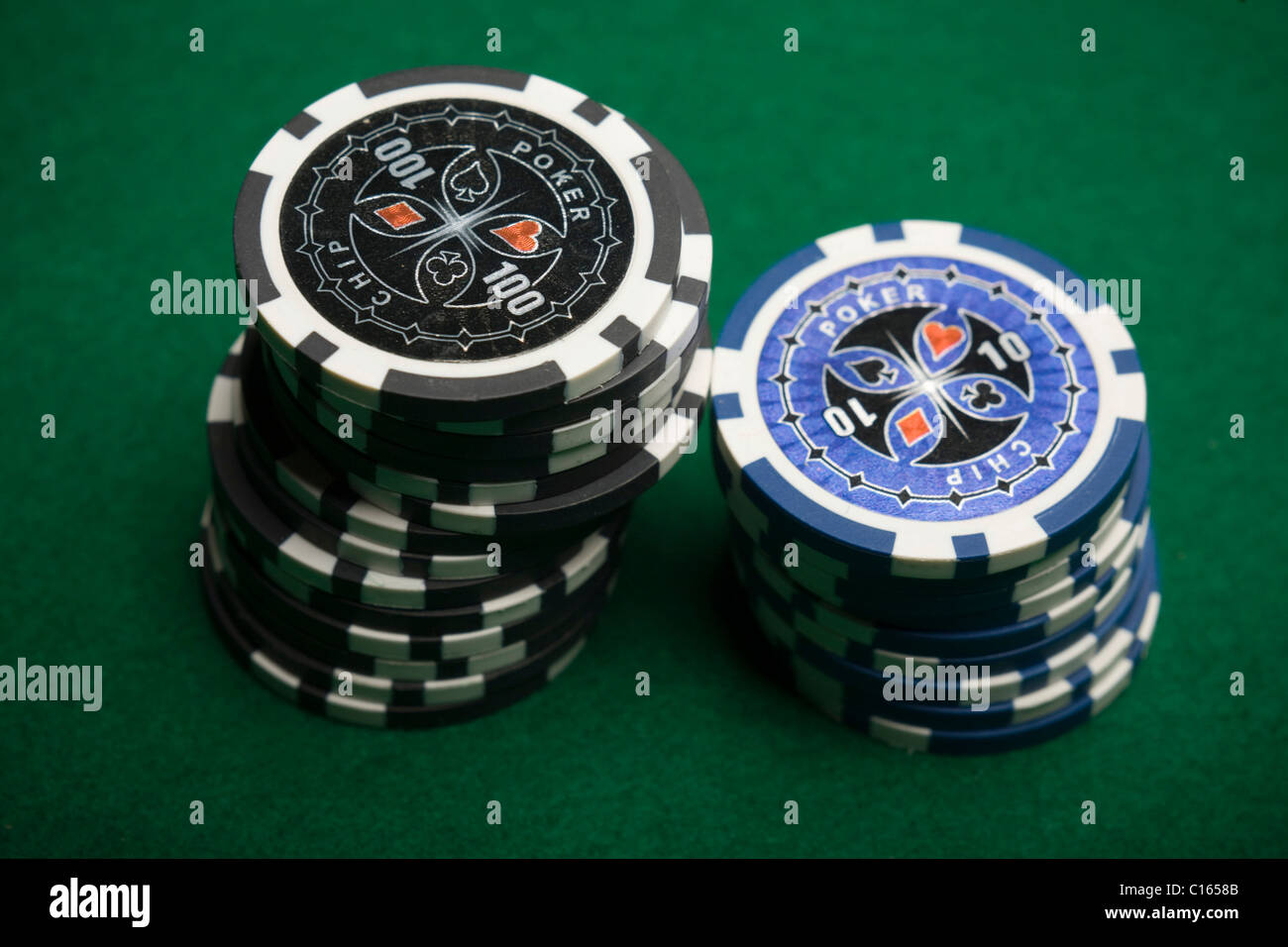 Schwarze und blaue Pokerchips auf grünen Filz gestapelt Stockfoto