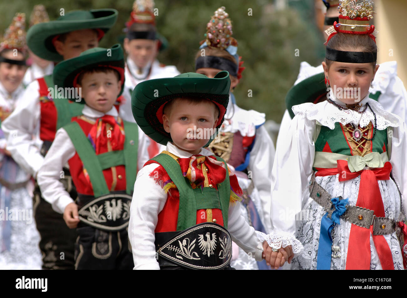 Kinder tragen Trachten des Tals Val Gardena während einer traditionellen Prozession in das Dorf Santa Cristina Stockfoto