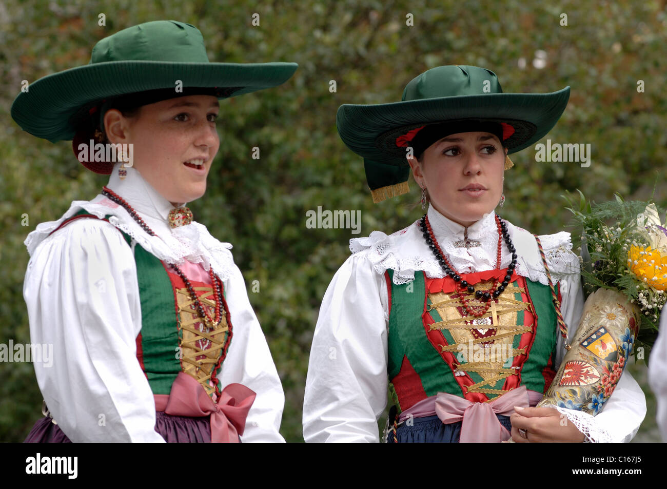 Junge Frauen tragen Trachten des Tals Val Gardena während einer traditionellen Prozession in das Dorf Santa Stockfoto