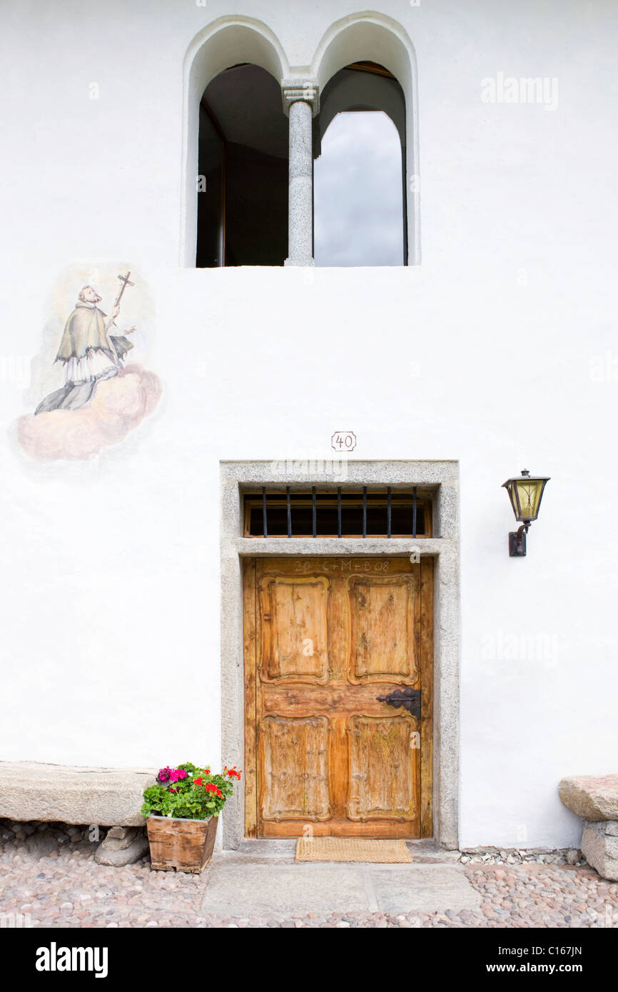 Bauernhaus-Gebäude-Fassade mit einem religiösen Motiv übermalt, einer alten Holztür, Sonnenburg, Bolzano-Bozen, Italien, Europa Stockfoto