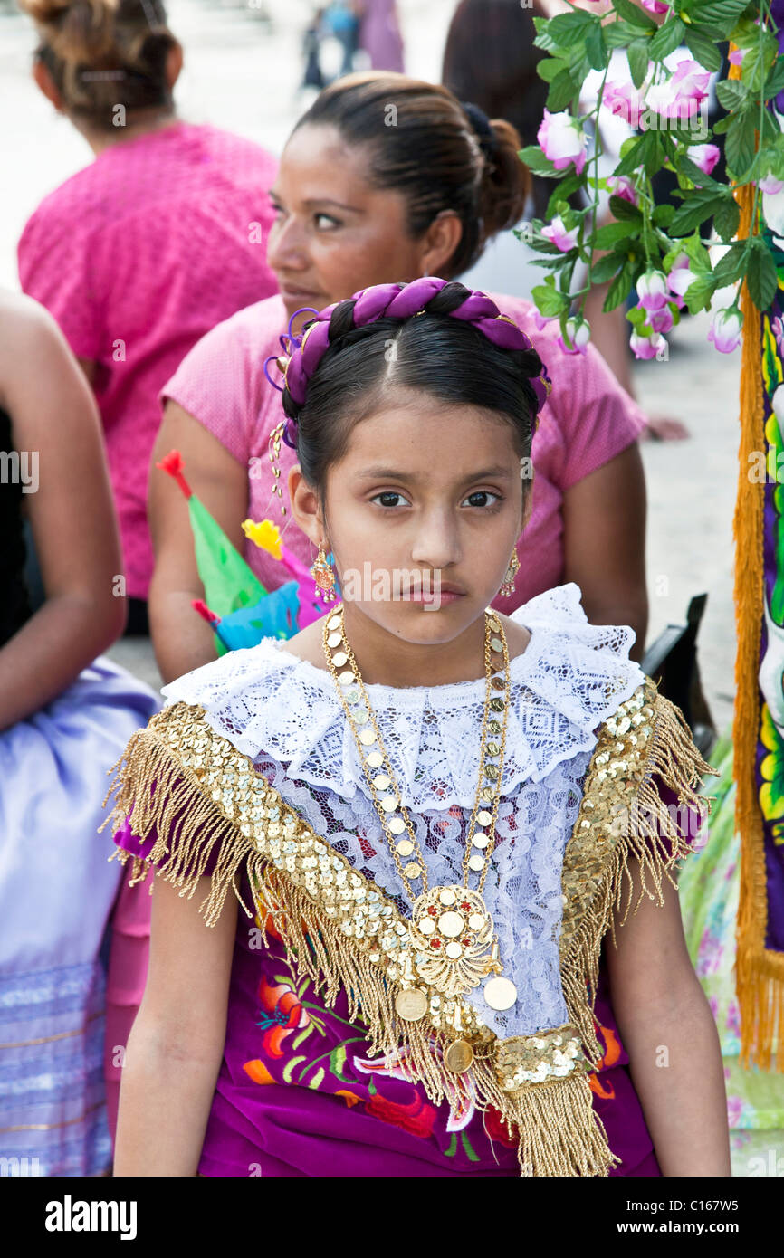 stolz auf durchdachte mexikanischen indigenen Mädchen kostümiert für kirchliche Festzug in traditioneller Tracht mit Multifunktionsleiste Kopfschmuck ins Haar geflochten Stockfoto