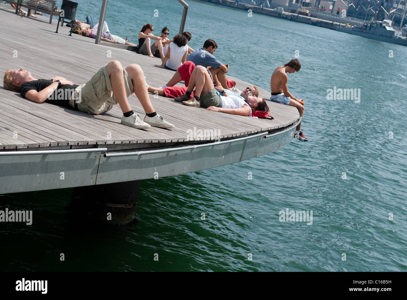 Menschen, die zum Sonnenbaden im Rambla del Mar, Barcelona Stockfoto