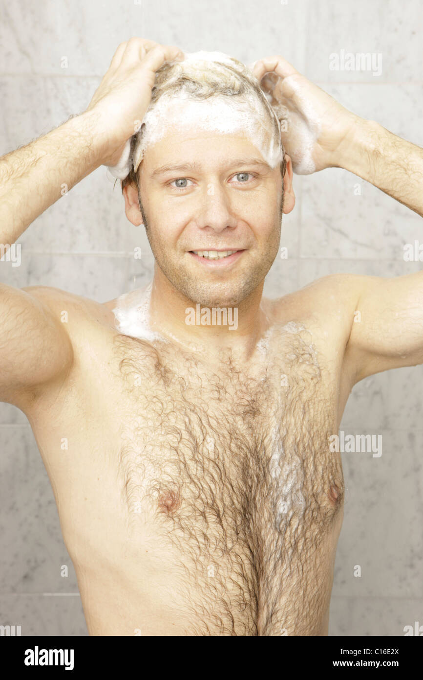 Ein Mann mit Brusthaar ist eine Dusche haben. Stockfoto