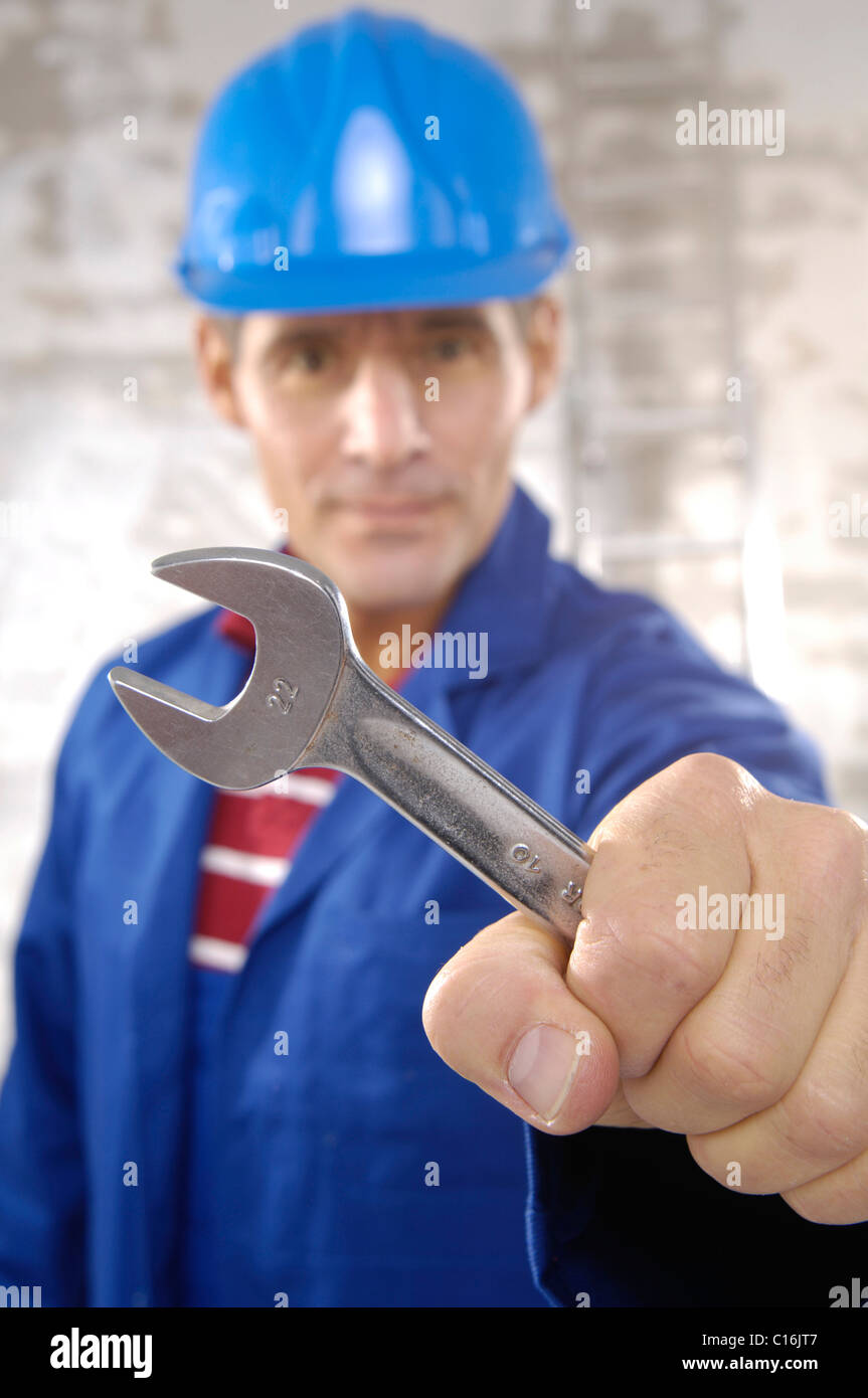 Arbeiter einen harten Hut hält eine Schraube-Schrauber Stockfoto